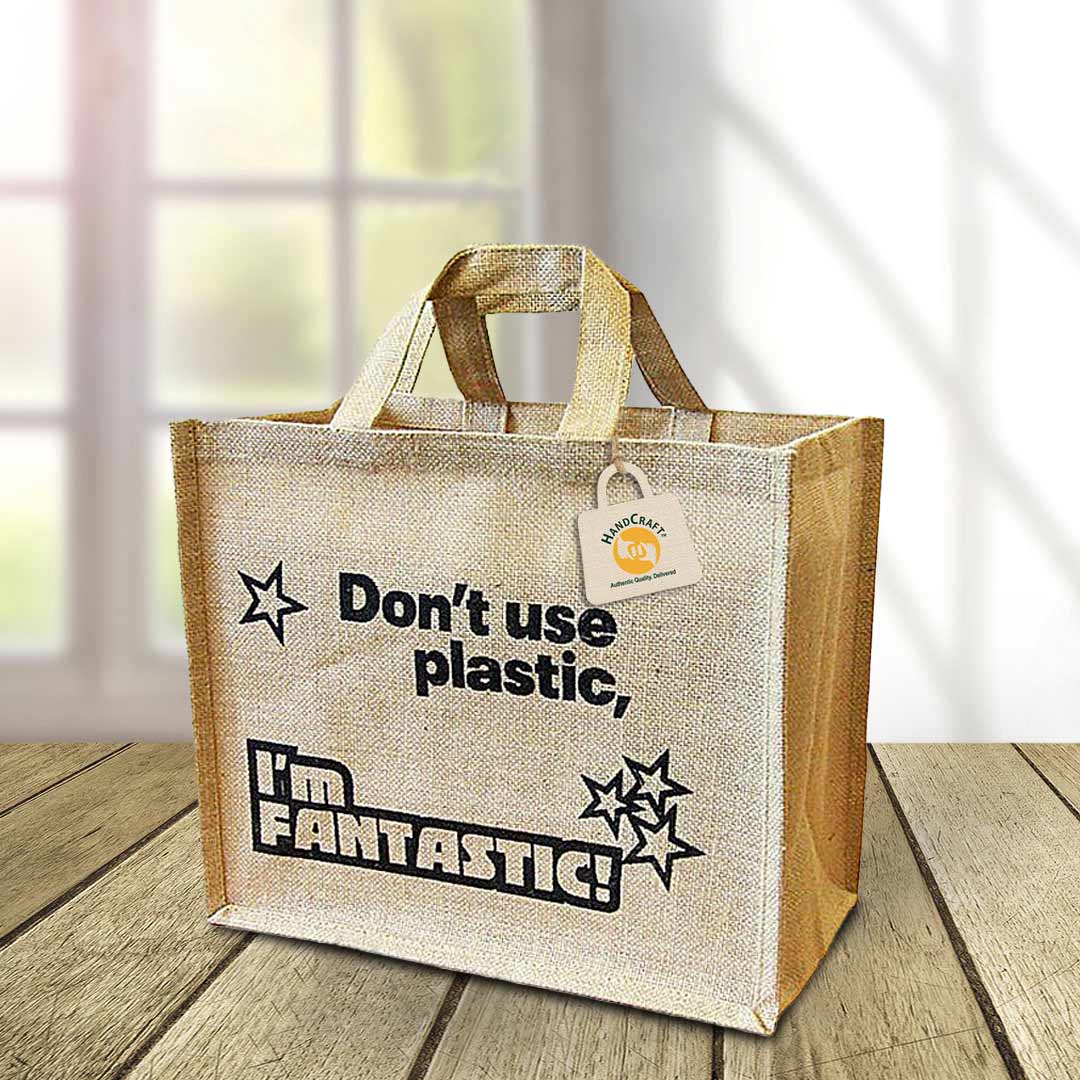 Natural-colour bag with a large black printed message and short flat handles.