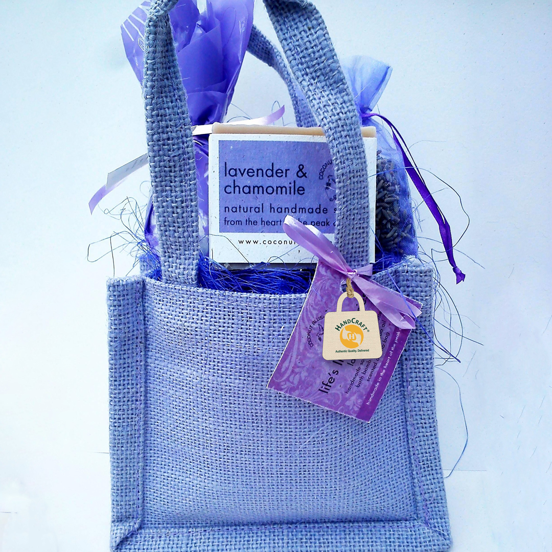 Purple gift bag containing wrapped gift items.