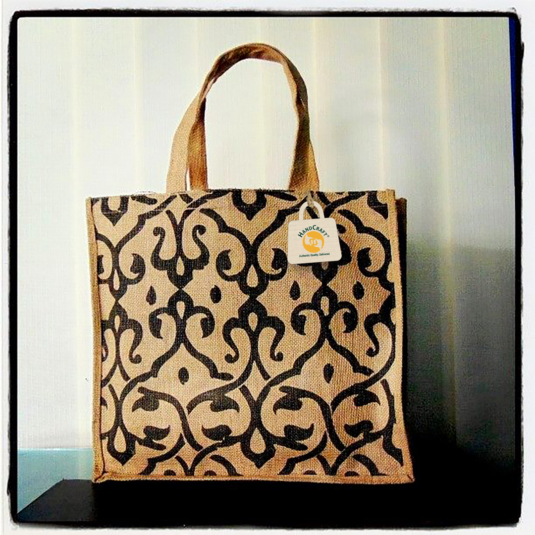 Natural-colour tote with a dark ornamental print and short handles.