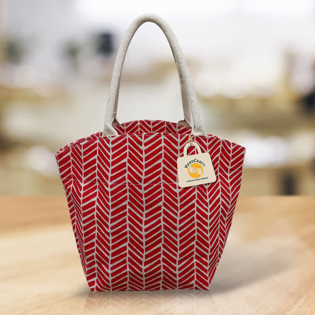 Bag with a red and white geometric print and cord handles.