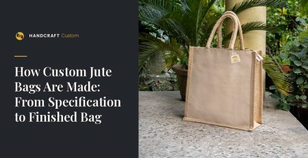 Plain natural-colour jute bag with padded rope handles and side gussets, standing on a stone ledge.