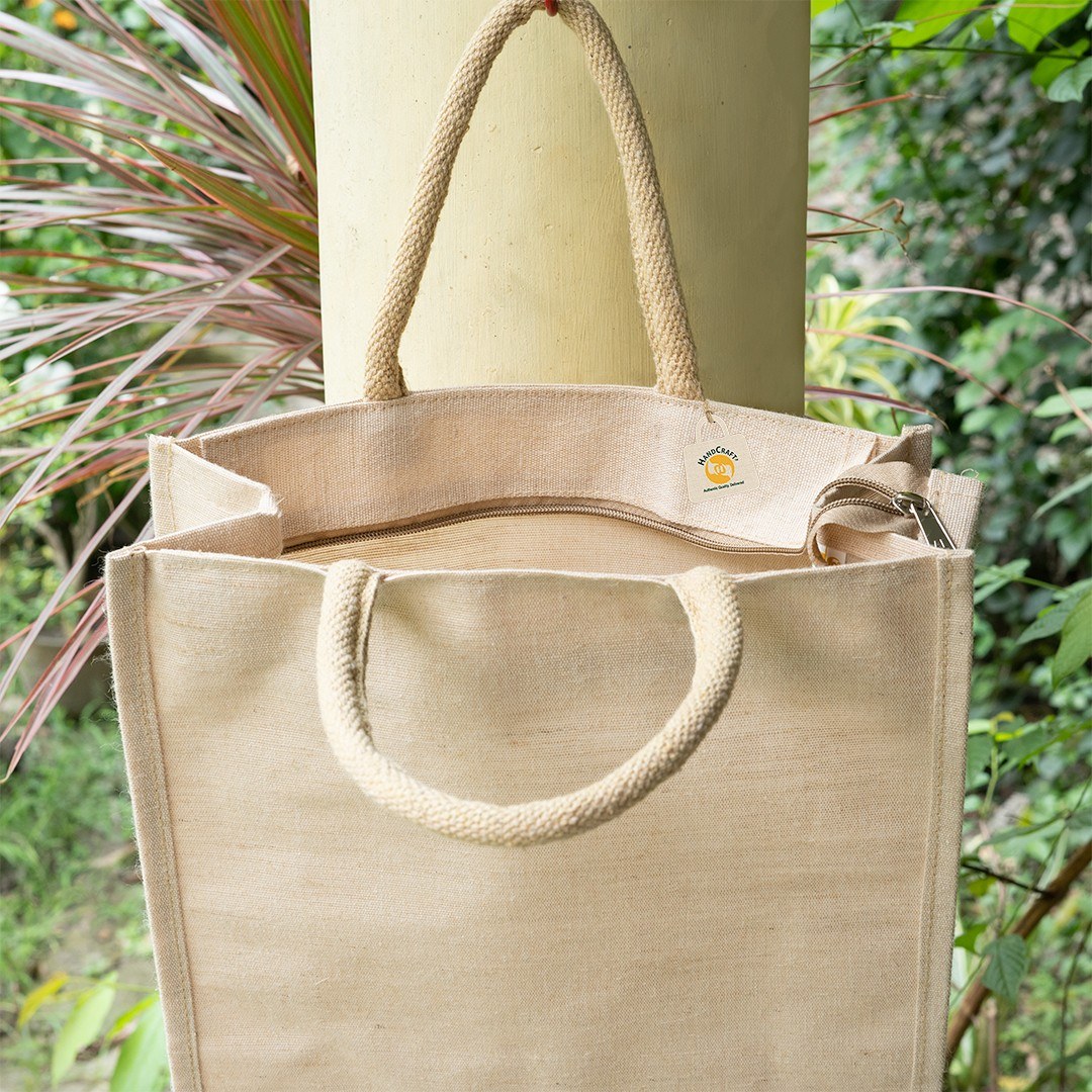 Plain natural-colour jute bag with rope handles, seen from above at the open top.