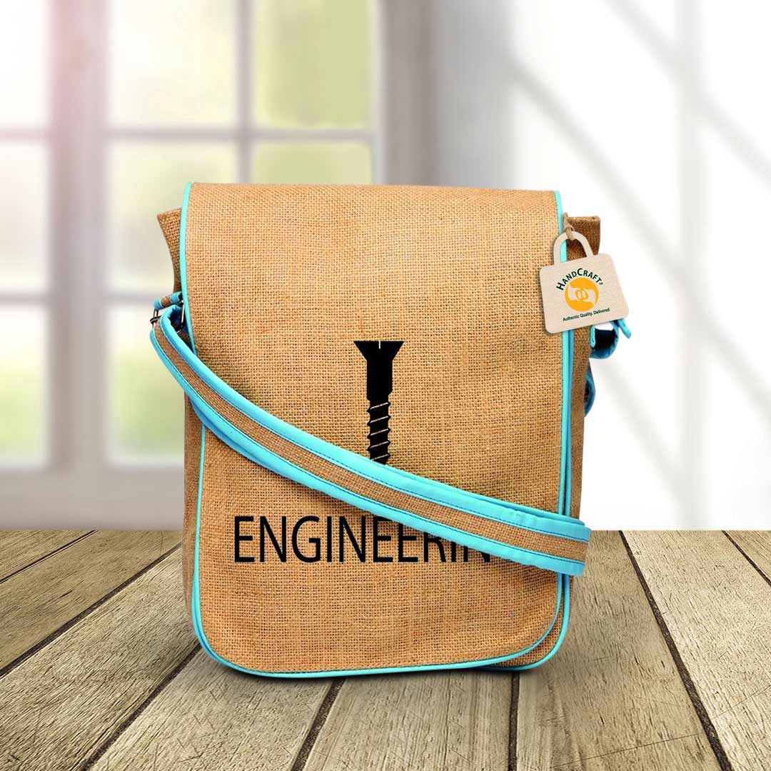 Tan shoulder bag with blue edging, printed artwork and a long strap.