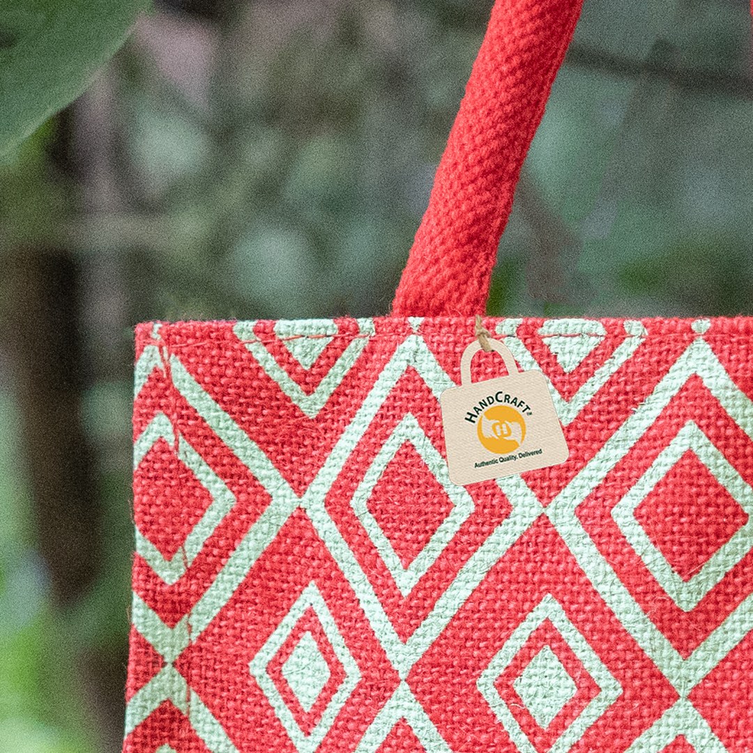 Close-up of red and green printed fabric beside a handle.