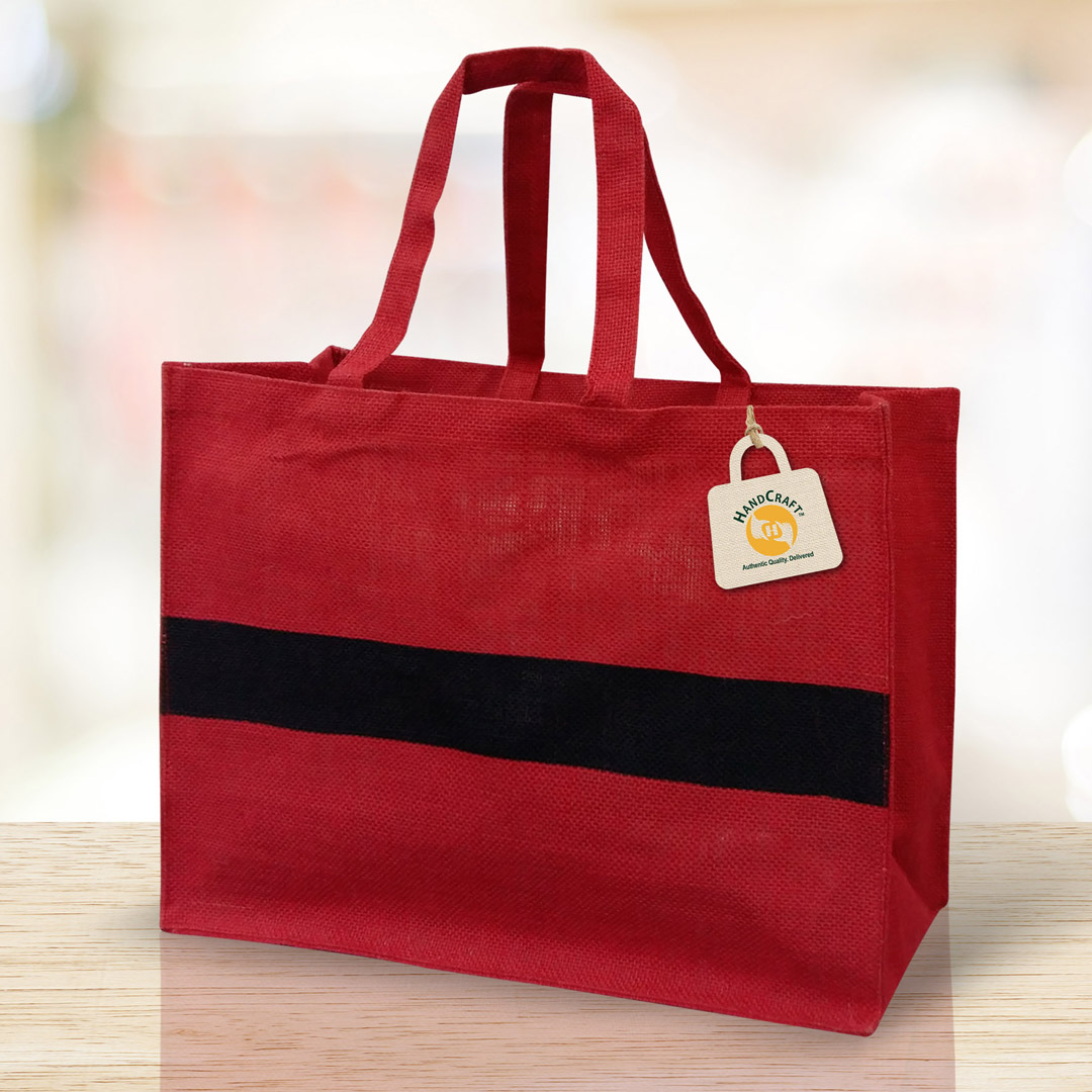 Rectangular bag with red flat handles and contrasting red and dark panels.