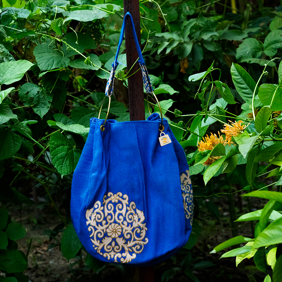 Blue bag with a gold ornamental design.