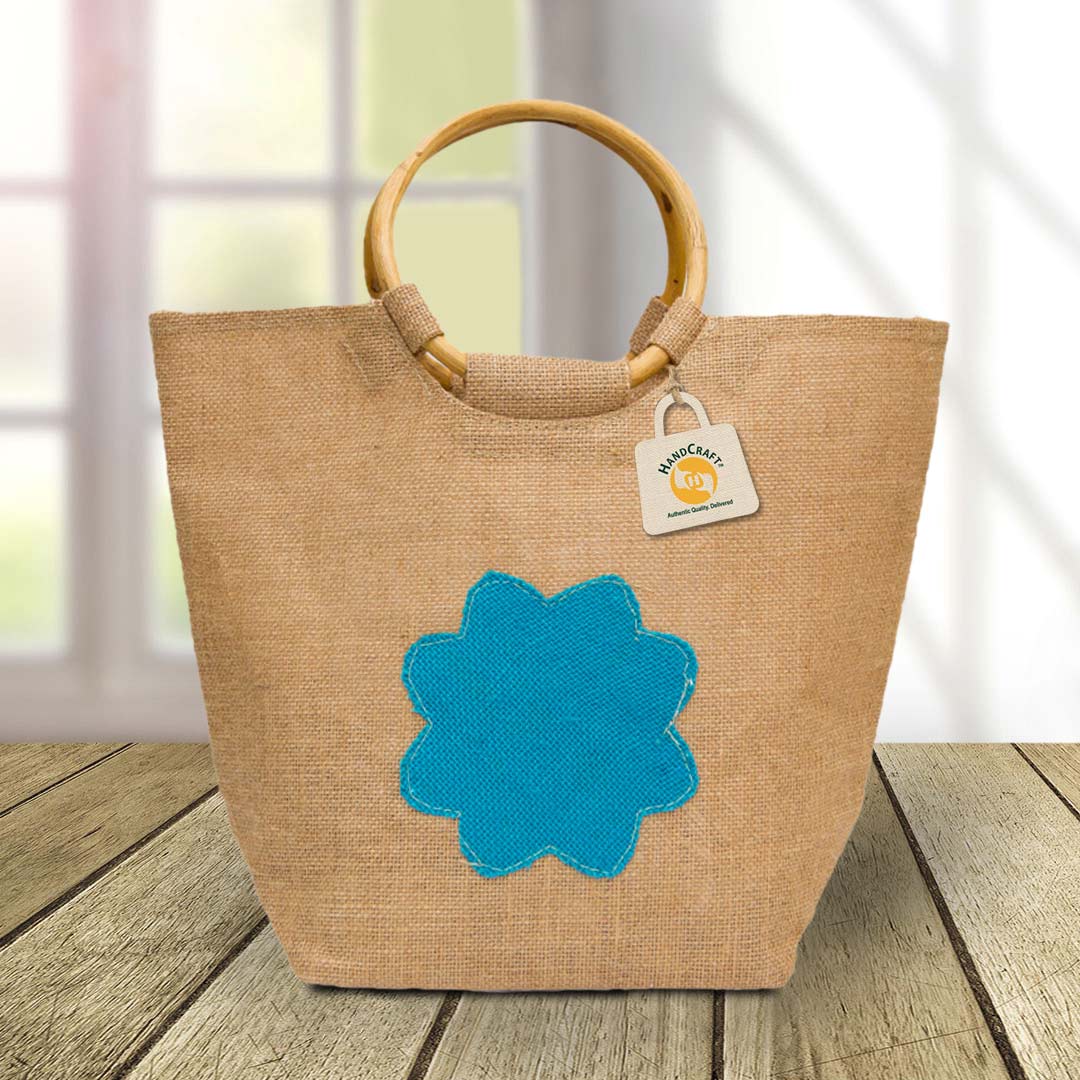 Natural-colour bag with blue decoration and rigid circular handles.